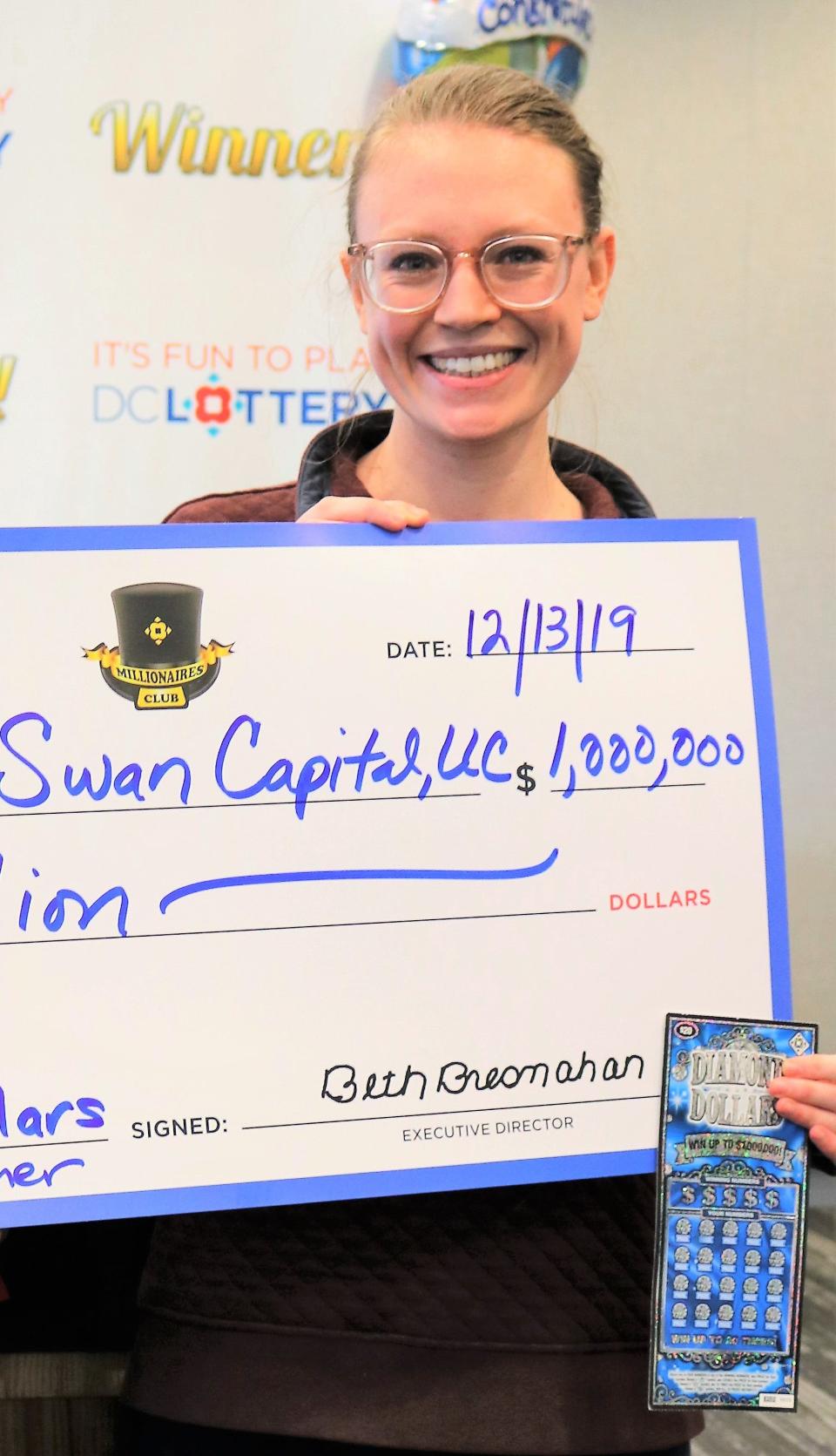 Hannah Davinroy holds a ceremonial check for $1 million after submitting a winning scratch-off ticket to the DC Lottery in December. The prize was paid out to a corporation called Black Swan Capital, LLC, which was established last year by two of her former classmates at Princeton University. The trio has won more than $6 million from scratch-off games from at least four different lotteries in the last 18 months.