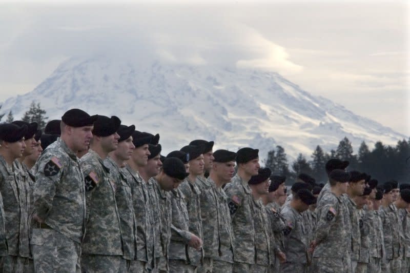 Underneath the backdrop of Mount Rainier, soldiers wait for a ceremony to begin at Fort Lewis in Tacoma, Wash., on October 11, 2007. On March 2, 1899, President William McKinley signed legislation establishing Mount Rainier National Park in Washington. File Photo by Jim Bryant/UPI