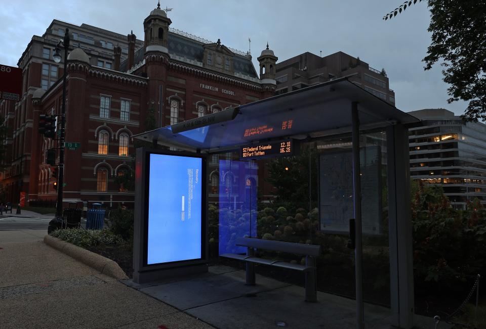 A blue Windows error message caused by the CrowdStrike software update is displayed on a screen in a bus shelter on July 22, 2024 in Washington, DC.
