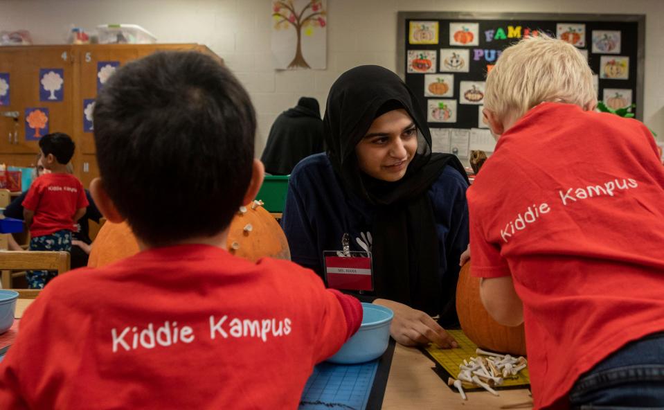 Hana Syed, a senior at Canton High School, helps two preschool students with their project during a Kiddie Campus class in Canton on Oct. 26, 2023. The Kiddie Campus class is one of the specialized classes offered at the Plymouth-Canton Educational Park that is geared toward students who might find a career related to early childhood education or teaching.
