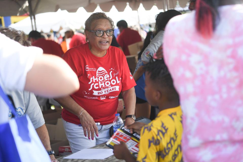 Volunteers distribute sneakers at Knoxville Area Urban League’s Shoes for School event in Caswell Park, Saturday, Aug. 6, 2022.