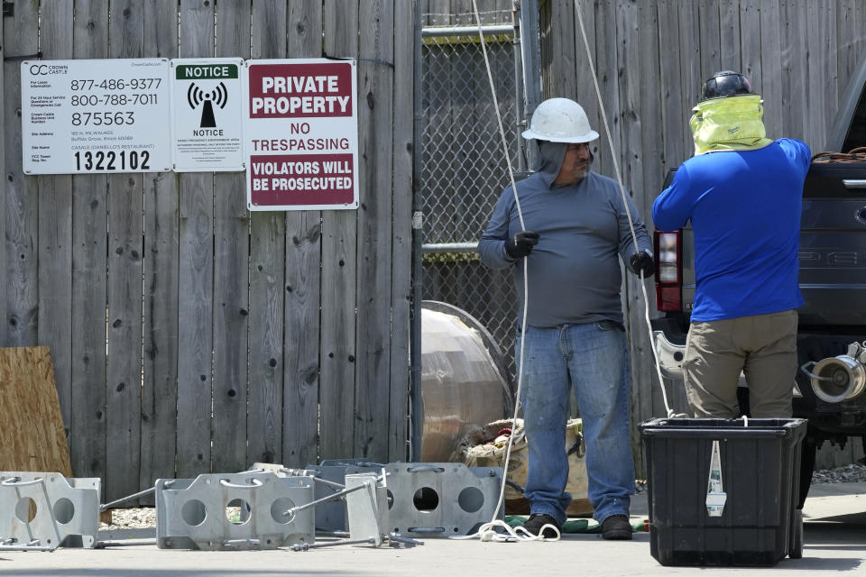 Workers in hot weather work at a Radio Frequency Environment area in Riverwoods, Ill., Monday, June 17, 2024. (AP Photo/Nam Y. Huh)