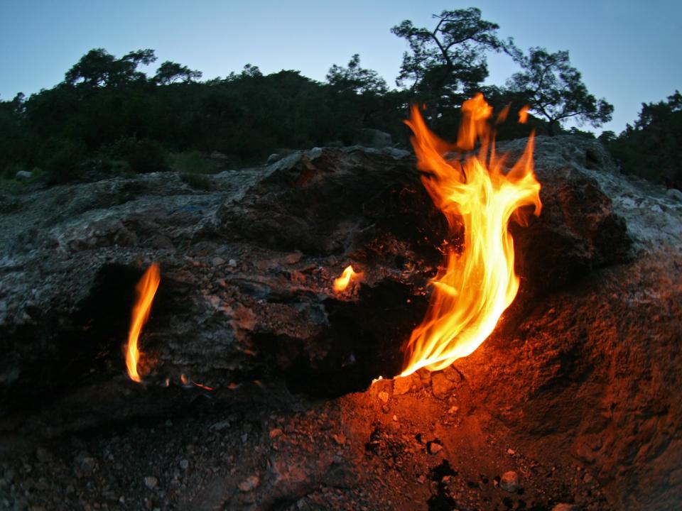 At the top of a mountain in southwest Turkey, the ground spits fire. Known as the Flames of Chimaera, they have burned for millenniums. Local myth long held that these fires were the breath of a monster – part goat, part snake, part lion.Today we know the fuel for this flaming mountaintop is gas escaping from deep within the earth. But it does not come from the decay of ancient plant, algae or animal life, like fossil fuels.Instead, this gas comes from a chemical reaction inside rocks. And a series of studies published by a group of international scientists known as the Deep Carbon Observatory is showing that this source of gas is more common on our planet than previously known.“We have discovered these unusual types of methane in many, many sites. It’s not a rare phenomenon,” said Giuseppe Etiope, a member of the group who helped discover the cause of the Flames of Chimaera in 2014.Over the past decade, the observatory’s community of scientists has found hundreds of gas deposits in more than 20 countries and several spots at the bottom of the sea that are similar to the Flames of Chimaera.And they’ve learned that the recipe for these gas emissions is far more complex than previously thought.“We now have a better understanding of the different way we can make methane on Earth. There’s not only the biological regime as we know it,” said Bénédicte Menez, a geomicrobiologist at the Institut de Physique du Globe de Paris.Abiotic methane, as it’s called, does nor involve decayed plants, animals or algae trapped in sedimentary rocks, like biotic methane. The chemical reactions that produce these gasses involve water and rocks sometimes miles below Earth’s surface.For years, Deep Carbon Observatory researchers have collected and analysed gas samples from hundreds of diverse sites. Using special tools to figure out where the methane came from, they have discovered Earth’s basic recipe: Take hydrogen from water. Mix with inorganic carbon from minerals or gas. Add another metal-rich mineral to get the process going, and voilà – abiotic methane.The hydrogen often comes from serpentinisation, when water percolates usually through rocks from the mantle. But the recipe varies. Different sites may use different minerals or carbons sourced from their environments: Hydrogen may come from friction, or radiolysis, instead of serpentinisation. Temperatures may range from below 121C, which can still support life, to around 482C, which can not.So the fires of Chimaera were the result of carbon-dioxide-rich limestone, or calcium carbonate and hydrogen-rich serpentinised rocks that were doused by rainwater.By contrast, in the ocean, at sites like the Lost City hydrothermal vent field, most methane formed under the higher temperatures produced when once-buried mantle rocks were exposed and serpentinised by circulating seawater.In each case, we see chemosynthesis – the deep-earth version of photosynthesis. Only its energy comes from a chemical reaction, not the sun. Both processes transform inorganic molecules to organic products life can use, which is the basis for all ecosystems on the planet.In some instances, chemosynthesis also produces amino acids, the building blocks of life.With the new tools designed to study Earth’s subsurface, researchers can determine whether methane came from ancient life or lifeless rocks. In doing so, they also reveal secrets about how life may have emerged on this planet – and the possibility for life elsewhere, like inside Mars or on the ocean floor of Saturn’s icy moon, Enceladus.Scientists like Menez think chemosynthesis may have come before photosynthesis, and allowed for emergence of microbes that eat and produce methane. “We know that life did not emerge from scratch.” she said.And finding parallels in the ways living microbes and lifeless chemical reactions produce methane, the microbes may contain clues about their origin too. "Early in Earth’s history life may have mimicked geological processes that naturally occurred,” she said.In the future, the researchers hope to learn how much of this methane is out there and where is it being stored.The New York Times