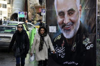 FILE - In this Jan. 9, 2020, file photo, women walk past a banner of Iranian Revolutionary Guard Gen. Qassem Soleimani, who was killed in Iraq in a U.S. drone attack, in Tehran, Iran. Iran has had its fingers in Iraq's politics for years, but the U.S. killing of an Iranian general and Iraqi militia commander outside Baghdad has added new impetus to the effort, stoking anti-Americanism that Tehran now hopes it can exploit to help realize the goal of getting U.S. troops out of the country. (AP Photo/Vahid Salemi, File)