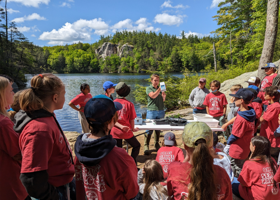 A representative from New Hampshire Fish and Game helps ORMS students with their water quality testing at Stonehouse Pond.