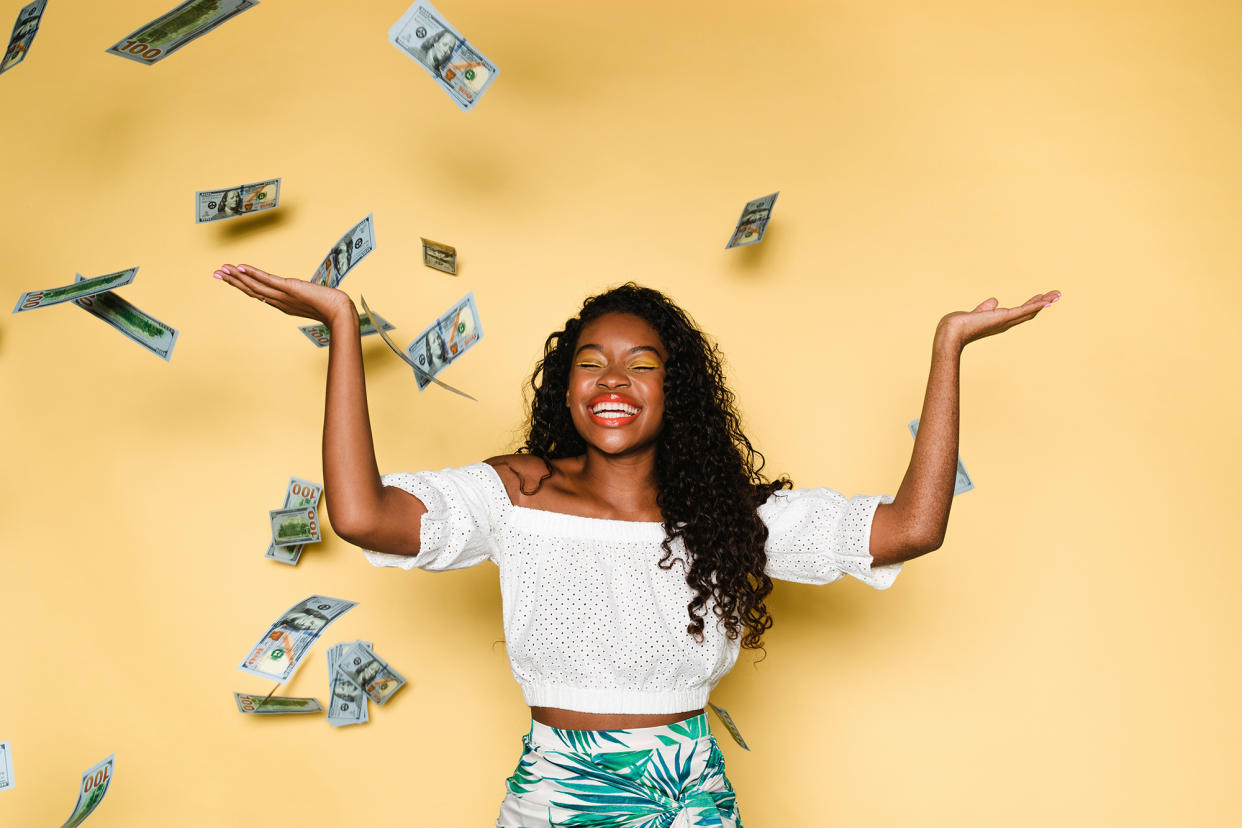 Happy woman throwing money in the air during summer vacation.