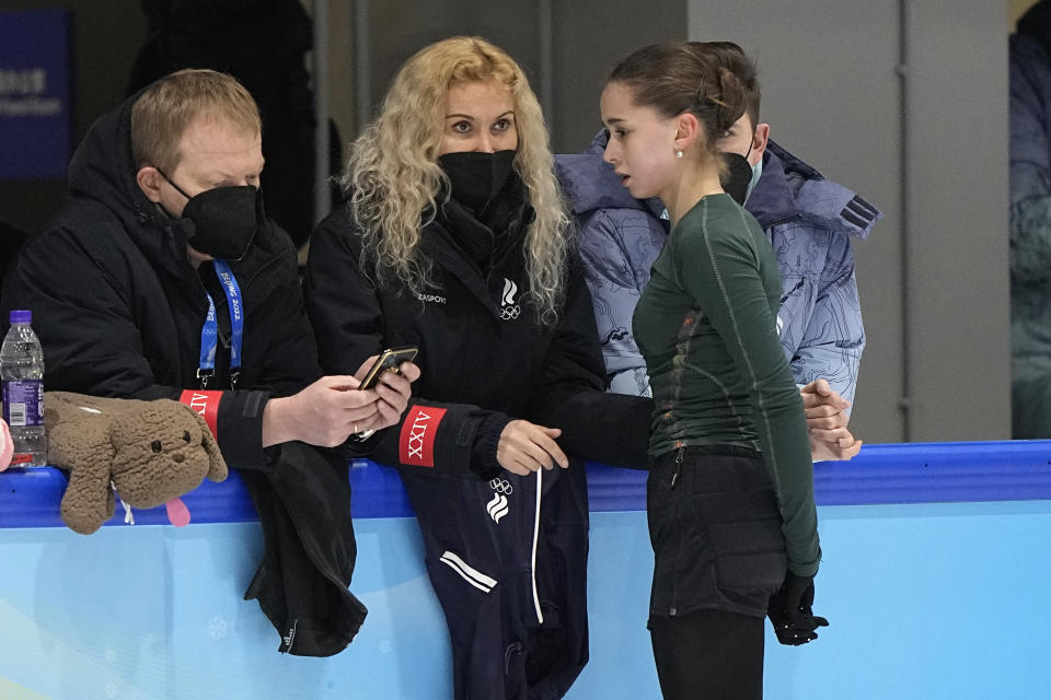 Coach Eteri Tutberidze, center, talks to Kamila Valieva, of the Russian Olympic Committee, during a training session at the 2022 Winter Olympics, Sunday, Feb. 13, 2022, in Beijing. (AP Photo/David J. Phillip)