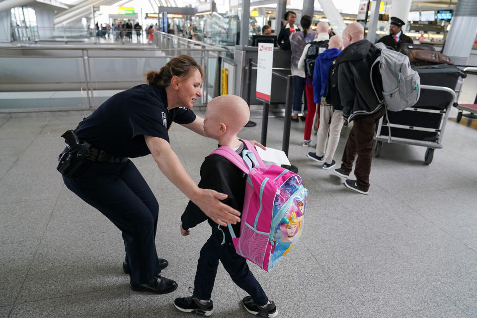 <p>Baraka Lusambo, 7, a Tanzanian with albinism who had his arm chopped off in a witchcraft-driven attack, hugs Teresa Piasecka, supervisory officer for U.S. Customs and Border Protection, before his flight home to Tanzania, at JFK airport in New York, June 6, 2017. (Photo: Carlo Allegri/Reuters) </p>