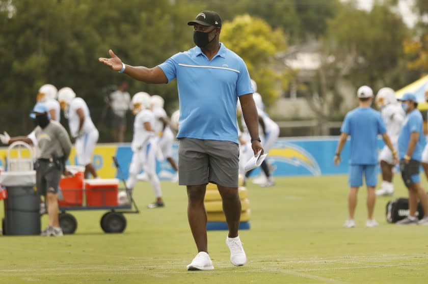 COSTA MESA, CA - AUGUST 17: Head Coach Anthony Lynn, center, works with players of the Los Angeles Chargers.