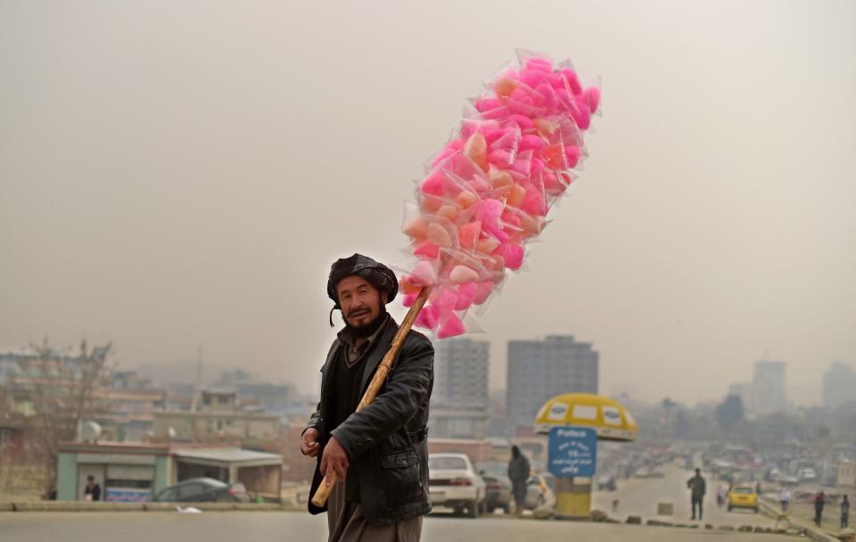 <p>An Afghan vendor sells candy floss as he walks on the streets of Kabul on January 5, 2017. (Photo: Shah Marai/ AFP/Getty Images) </p>