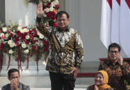 Newly appointed Defense Minister Prabowo Subianto who is the former rival of Indonesian President Joko Widodo in last April's election, waves as he is introduced during the announcement of the new cabinet at Merdeka Palace in Jakarta, Indonesia, Wednesday, Oct. 23, 2019. (AP Photo/Dita Alangkara)