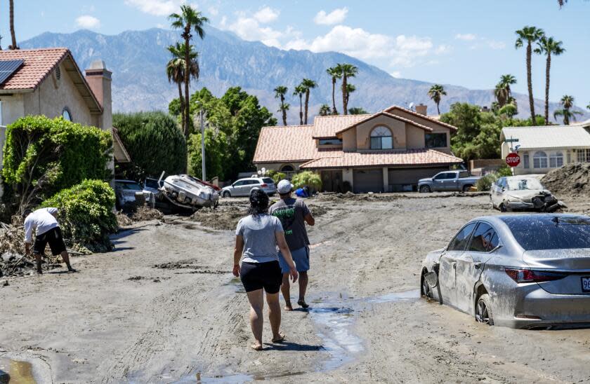 CATHEDRAL CITY, CA - AUGUST 22, 2023: Residents walk towards Horizon Road amid the destruction after tropical storm Hilary sent damaging flood water to the area Sunday night on August 22, 2023 in Cathedral City, California. (Gina Ferazzi / Los Angeles Times)