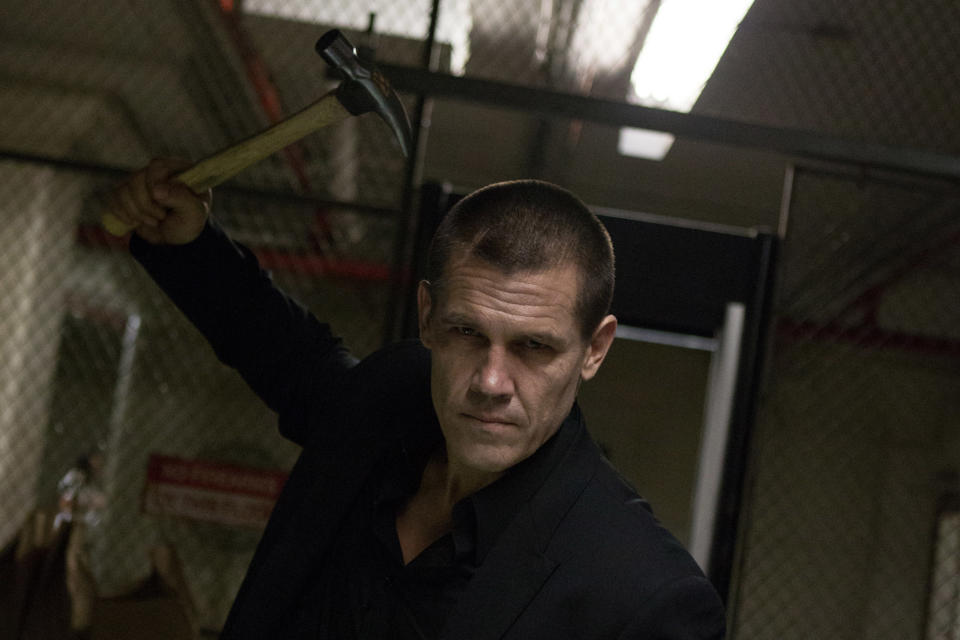 Josh Brolin holds up a hammer before a battle