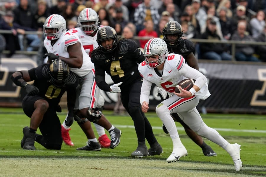 Ohio State quarterback Kyle McCord (6) runs past Purdue linebacker Kydran Jenkins (4) during the first half of an NCAA college football game, Saturday, Oct. 14, 2023, in West Lafayette, Ind. (AP Photo/Darron Cummings)
