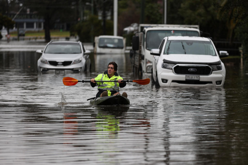A kayaker paddles through a flooded residential area following heavy rains in the South Windsor suburb of Sydney, Australia, July 5, 2022.  REUTERS/Loren Elliott