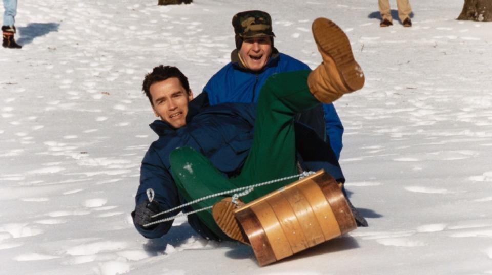 U.S. President George Bush takes a toboggan ride with Austrian actor Arnold Schwarzenegger at Camp David. <p>Getty Images</p>