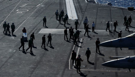 Crew members work on the deck of the USS Ronald Reagan in the South China Sea September 30, 2017. REUTERS/Bobby Yip