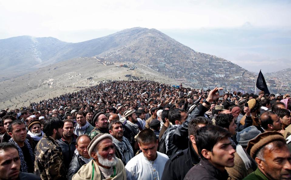 Afghan men attend the burial of Afghanistan's influential Vice President Mohammad Qasim Fahim during his funeral procession in Kabul, Afghanistan, Tuesday, March 11, 2014. Fahim, a leading commander in the alliance that fought the Taliban who was later accused with other warlords of targeting civilian areas during the country's civil war, died on Sunday, March 9, 2014. He was 57. (AP Photo/Massoud Hossaini)