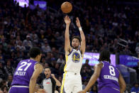 Golden State Warriors guard Klay Thompson (11) shoots against Utah Jazz forward's Darius Bazley (21) and Brice Sensabaugh (8) during the first half of an NBA basketball game in San Francisco, Sunday, April 14, 2024. (AP Photo/Jed Jacobsohn)