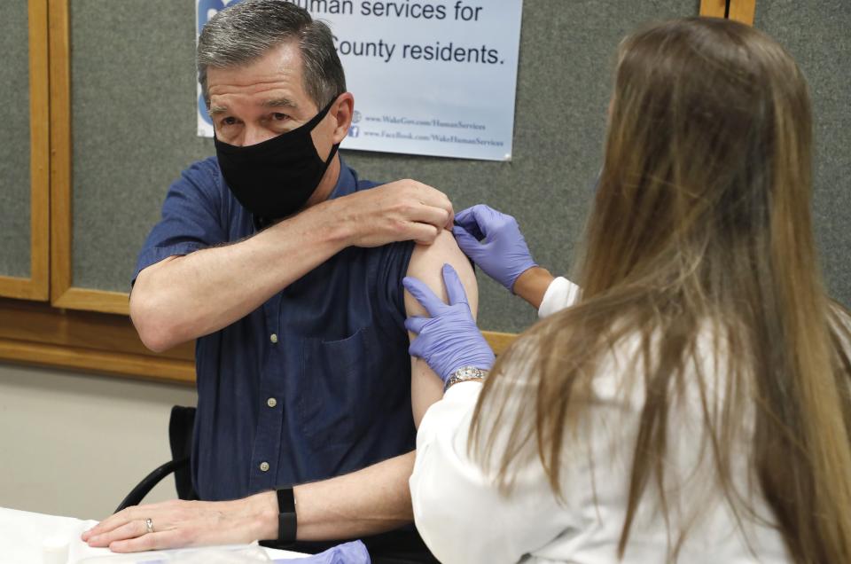 Michelle Winings, R.N., prepares to give Gov. Roy Cooper his flu shot at the Wake County Health Department in Raleigh, N.C., Friday, Sept. 25, 2020. (Ethan Hyman/The News & Observer via AP)