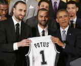 U.S. President Barack Obama poses for a team photo next to players Manu Ginobili (L) and Tony Parker (C) while holding a team jersey as he welcomes the 2014 NBA Champion San Antonio Spurs to the East Room of the White House in Washington, January 12, 2015. REUTERS/Larry Downing (UNITED STATES - Tags: POLITICS SPORT BASKETBALL)