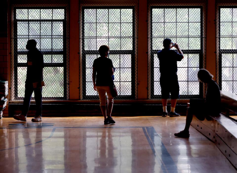 Former Gesu School students check out the gymnasium they used, during the tour of their old school for the 100-year celebration at Gesu Catholic Church and School in Detroit on Saturday, July 30, 2022.