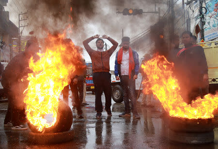 Demonstrators shout slogans next to burning tyres during a protest against the killing of a leader of India's ruling Hindu nationalist Bharatiya Janata Party's (BJP), and his brother by unidentified gunmen in Kishtwar town, in Jammu November 2, 2018. REUTERS/Mukesh Gupta