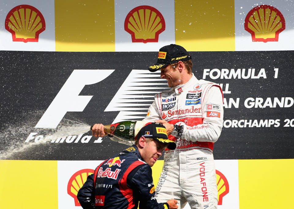 SPA, BELGIUM - SEPTEMBER 02: Race winner Jenson Button (R) of Great Britain and McLaren celebrates on the podium with second placed Sebastian Vettel (L) of Germany and Red Bull Racing following the the Belgian Grand Prix at the Circuit of Spa Francorchamps on September 2, 2012 in Spa Francorchamps, Belgium. (Photo by Clive Mason/Getty Images)