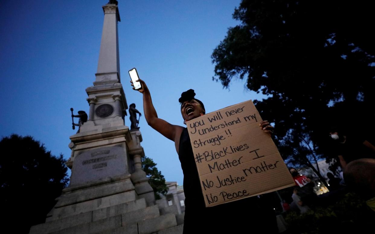 A protester speaks to the crowd underneath the Confederate monument last month during nationwide unrest following the death of George Floyd - Reuters