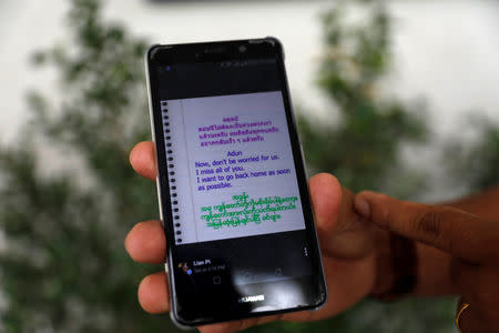 A relative shows a transcript of a message from a boy of nicknamed Adun, one of the 12 schoolboys trapped in a flooded cave, at a prayer session at Mesai Grace Church, in the northern province of Chiang Rai, Thailand, July 8, 2018. REUTERS/Soe Zeya Tun