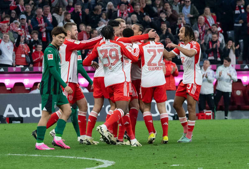 Munich players celebrate their third goal during the German Bundesliga soccer match between Bayern Munich and Borussia Moenchengladbach at the Allianz Arena. Niklas Treppner/dpa