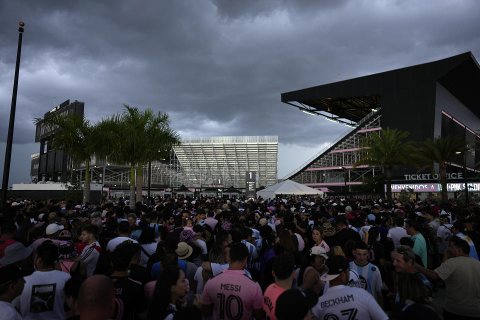 Fans wait to enter DRV Pink Stadium, home of the Inter Miami MLS soccer team, for an event to present international superstar Lionel Messi the day after the team finalized his signing through the 2025 season, Sunday, July 16, 2023, in Fort Lauderdale, Fla. (AP Photo/Rebecca Blackwell)