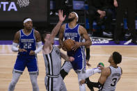 Sacramento Kings forward Marvin Bagley III (35) is fouled on his way to the basket by San Antonio Spurs forward Keldon Johnson (3) as Spurs center Jakob Poeltl (25) helps defend during the first quarter of an NBA basketball game in Sacramento, Calif., Friday, May 7, 2021. (AP Photo/Hector Amezcua)