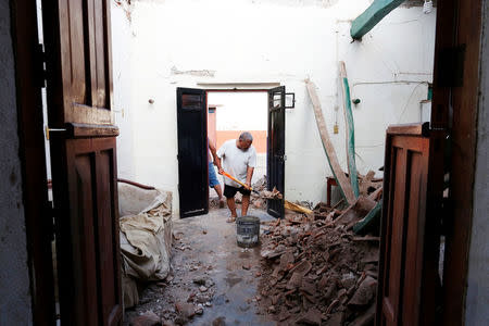 A man clears the debris of his house that was damaged in an earthquake that struck the southern coast of Mexico late on Thursday, in Juchitan, Mexico, September 9, 2017. REUTERS/Carlos Jasso