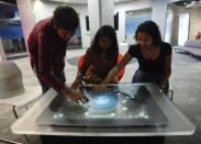Employees demonstrate the use of the newly-designed prototype of a touch-sensitive table at Microsoft India's Development Center in the Gachibowli IT district in Hyderabad, in the southern state of Andhra Pradesh March 6, 2012.