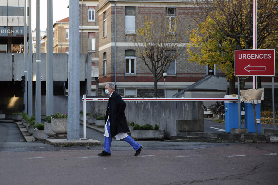 Dr. Philippe Montravers walks near the main entrance of the Bichat Hospital, in Paris on Tuesday, Nov. 10, 2020. Montravers and the 150 doctors and nurses he leads have become experts about how to treat COVID-19. That knowledge is proving invaluable against a second deadly surge of the virus is again threatening to overwhelm European health systems. (AP Photo/Francois Mori)