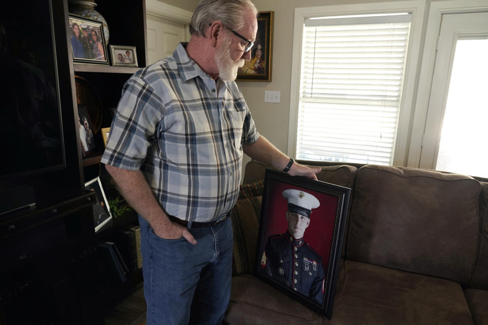 Joey Reed holds a portrait of his son Marine veteran and Russian prisoner Trevor Reed at his home in Fort Worth, Texas, Tuesday, Feb. 15, 2022. Russia is holding Trevor Reed, who was sentenced to nine years on charges he assaulted a police officer. (AP Photo/LM Otero)