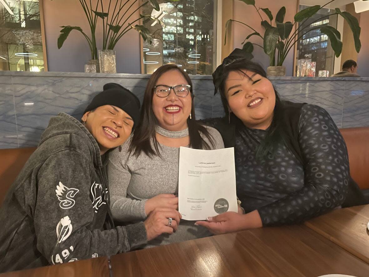 Scott Wabano, left, Geraldine Shecapio, centre, and Jomarie Einish pose with an official document recognizing Two Spirits of Eeyou Istchee as a non-profit organization. (Submitted by Jomarie Einish - image credit)