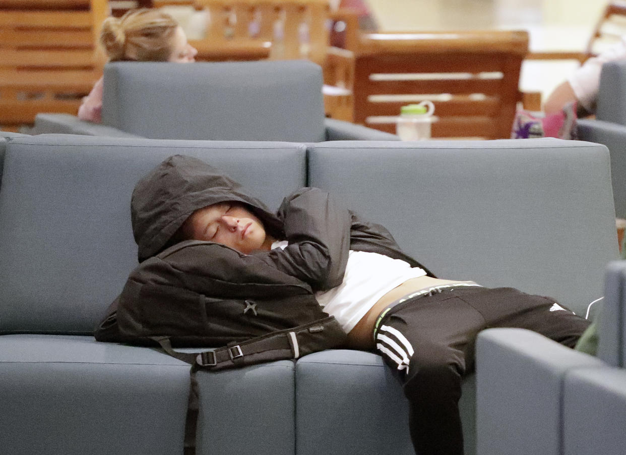 A traveler catches up on some sleep while waiting for a flight at Orlando International Airport, Wednesday, Nov. 21, 2018, in Orlando, Fla., before the start of the Thanksgiving holiday. (AP Photo/John Raoux)