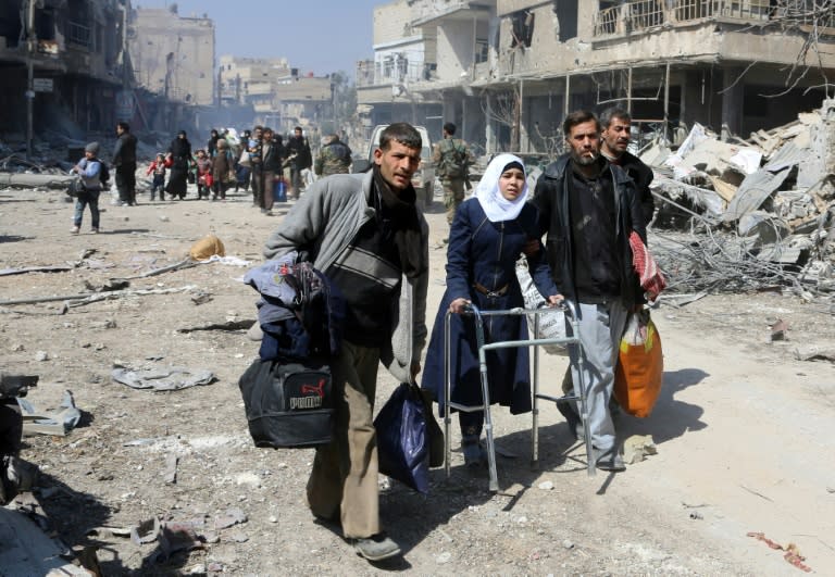 Syrian civilians flee from the town of Jisreen in the Eastern Ghouta enclave on the way to areas under government control on March 17, 2018