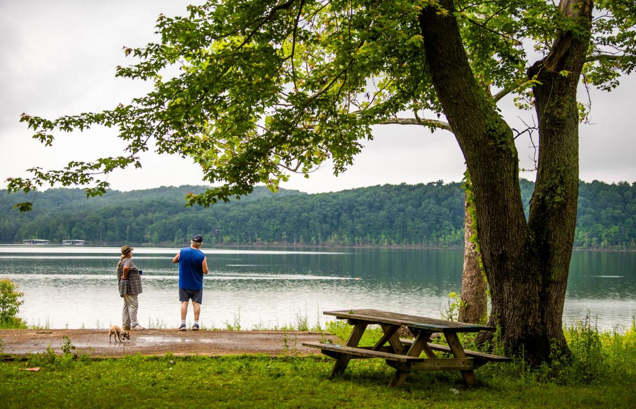 Linda Schloesser, left, and Paul McGlocklin, right, enjoy their morning coffee with their dog Buddy while looking over Lake Monroe at the Cutright State Recreation Area on Wednesday, June 9, 2021.