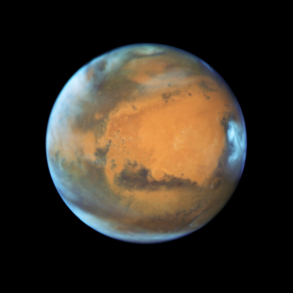 Mars as it was observed shortly before opposition in May 2016 by the Hubble Space Telescope. Some prominent features are clearly visible, including the heavily eroded Arabia Terra in the center of the image and the small