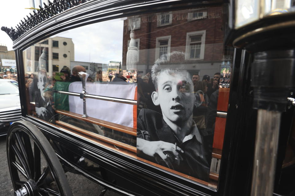 The funeral procession of Shane MacGowan makes its way through the streets of Dublin, ahead of his funeral in Co Tipperary, in Ireland, Friday, Dec. 8, 2023. MacGowan, the singer-songwriter and frontman of The Pogues, best known for their ballad “Fairytale of New York,” died on Thursday, Nov. 30, 2023. He was 65. (Liam McBurney/PA via AP)