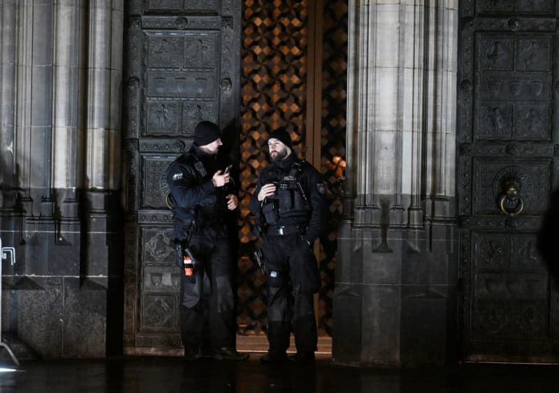 Police officers secure an entrance to Cologne Cathedral.  A 30-year-old Tajik man arrested on December 24 in connection with a terrorist threat to Cologne Cathedral remains in custody two weeks after his arrest, police in the western German city said on January 07. Roberto Pfeil/dpa