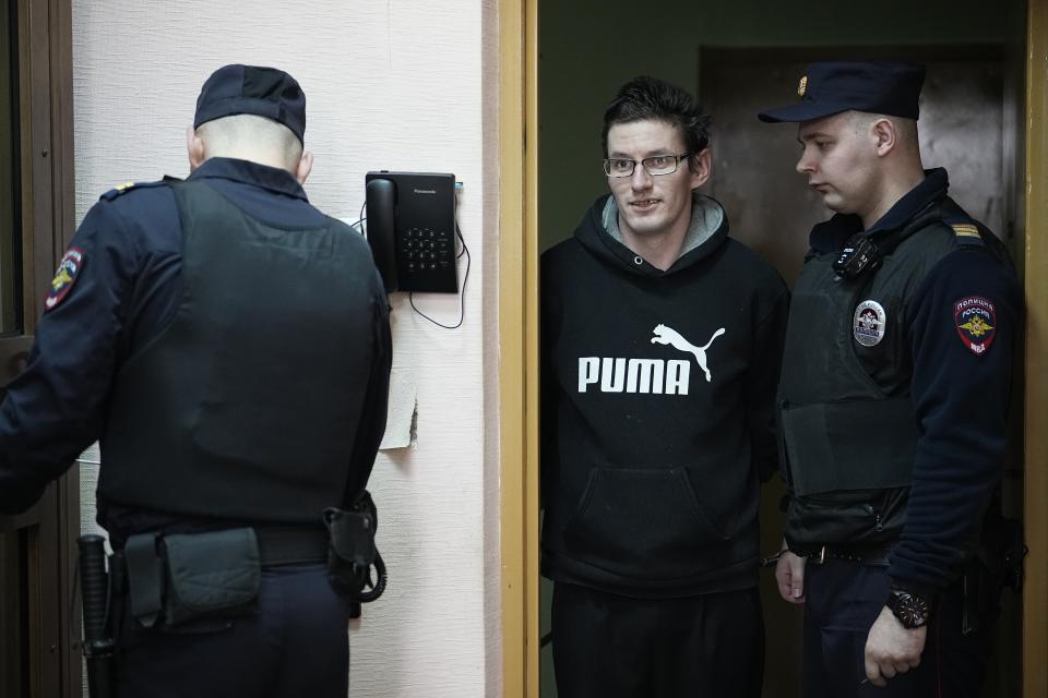 U.S. citizen Robert Woodland Romanov, center, is escorted into a glass cage prior to a court session on drug-related charges in Moscow, Russia, on Thursday, April 25, 2024. The U.S. citizen arrested on drug charges in Moscow amid soaring Russia-U.S. tensions has appeared in court. Robert Woodland Romanov is facing charges of trafficking large amounts of illegal drugs as part of an organized group — a criminal offense punishable by up to 20 years in prison. (AP Photo/Alexander Zemlianichenko)