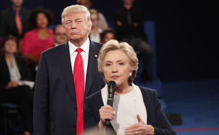 Republican U.S. presidential nominee Donald Trump listens as Democratic nominee Hillary Clinton answers a question from the audience during their presidential town hall debate at Washington University in St. Louis, Missouri, U.S., October 9, 2016. REUTERS/Rick Wilking