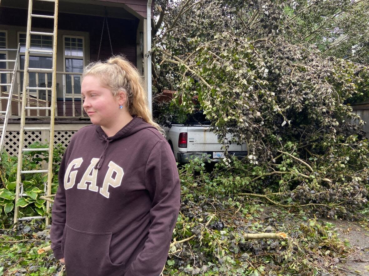Hannah Marks of Sydney stands in front of her family's Union Street home that was damaged from the impacts of the storm.  (Erin Pottie/CBC - image credit)
