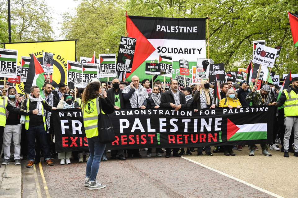 People hold placards and Palestinian flags as they march in solidarity with the Palestinian people amid the ongoing conflict with Israel, during a demonstration in London, Saturday, May 15, 2021.(AP Photo/Alberto Pezzali)