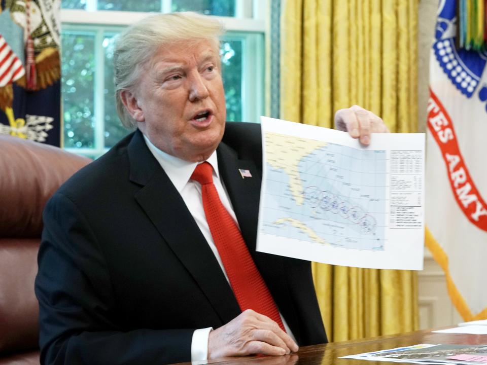 U.S. President Donald Trump shows reporters a map of a predicted path of Hurricane Dorian following a briefing from officials in the Oval Office at the White House September 04, 2019 in Washington, DC.