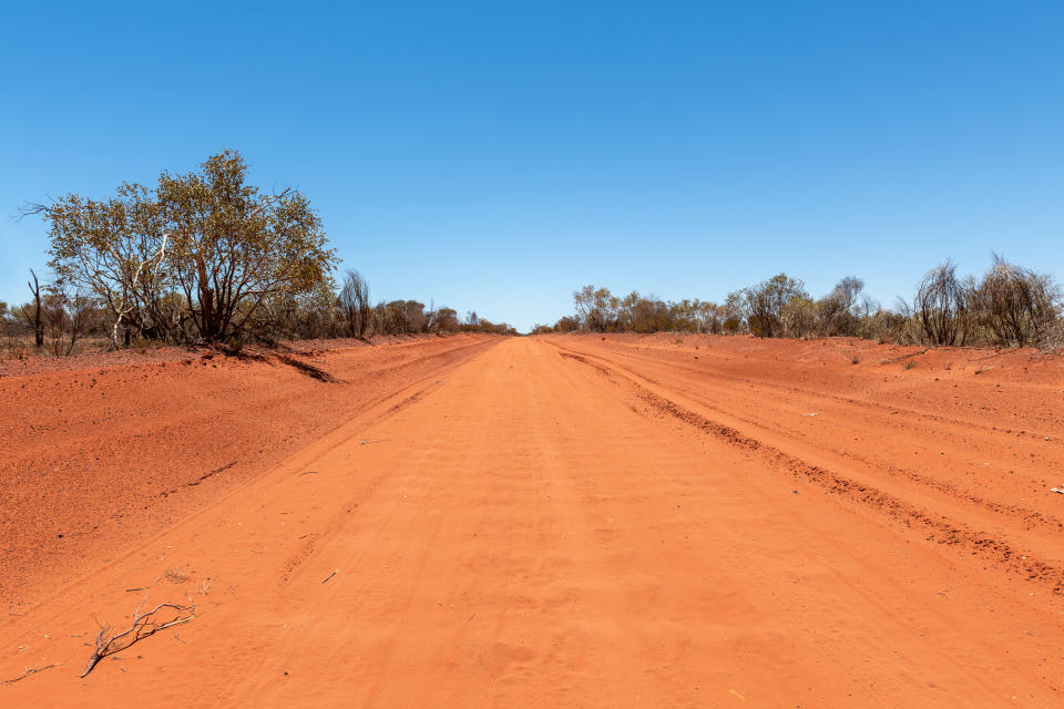 A dirt road in the red centre of the Australian outback in the Northern Territory. 